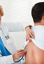 A female doctor examining, with a stethoscope, the  breathing sounds of the lungs 