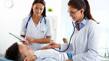 Two female doctors investigating a young, male pacient